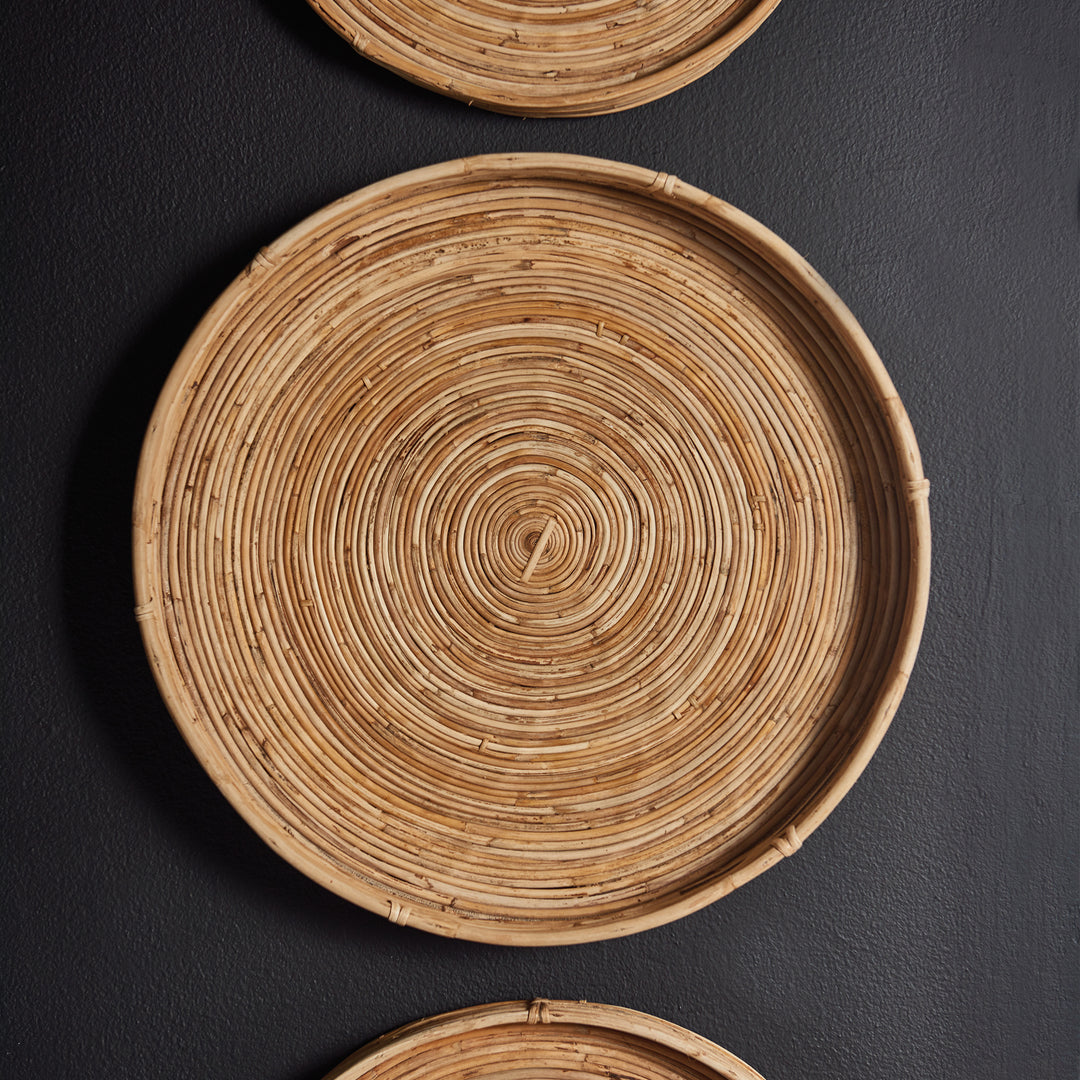 Vertical set of three round rattan trays styled as wall decor - boho natural design statement