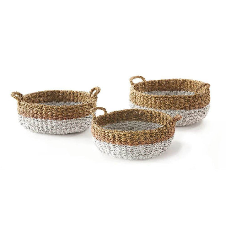 Set of three low round seagrass baskets with white-dipped base and braided handles, displayed on white background – Coastal Casual.

