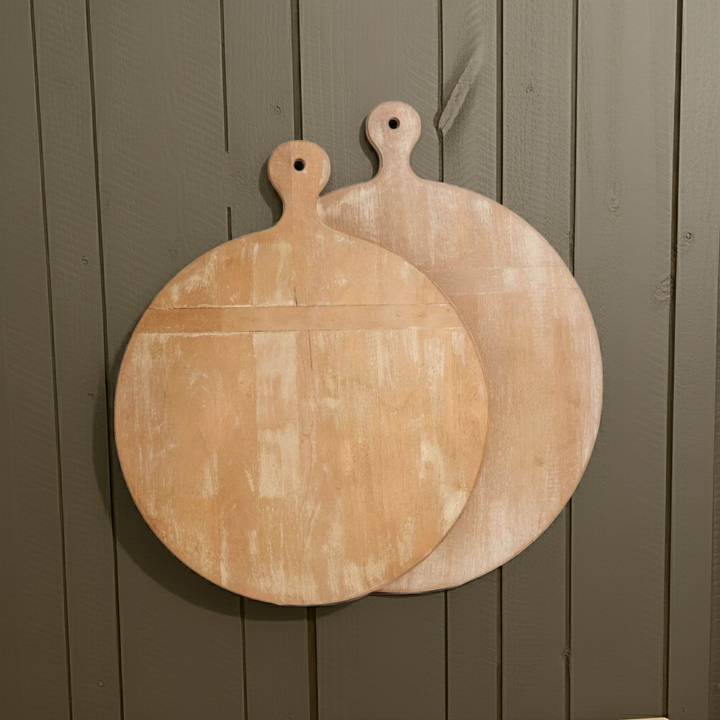 Set of round wooden cutting boards in rustic whitewash finish, styled leaning on dark wood paneled wall – Farmhouse Vintage