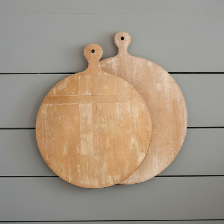 Pair of antique style round wooden cutting boards with handles, whitewashed finish displayed against light gray wall – Farmhouse Vintage