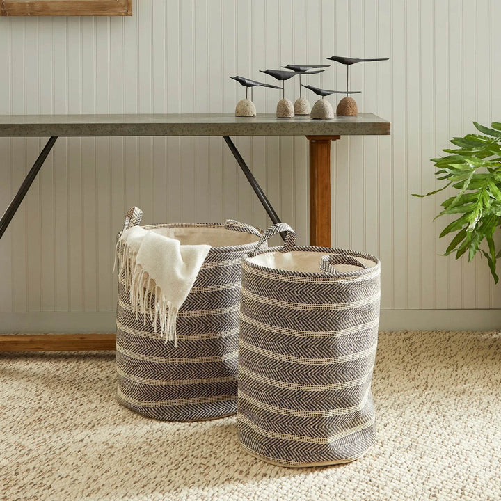 Round woven storage baskets with handles styled with a throw blanket in a cozy room, decorative organization accent – Modern Organic.

