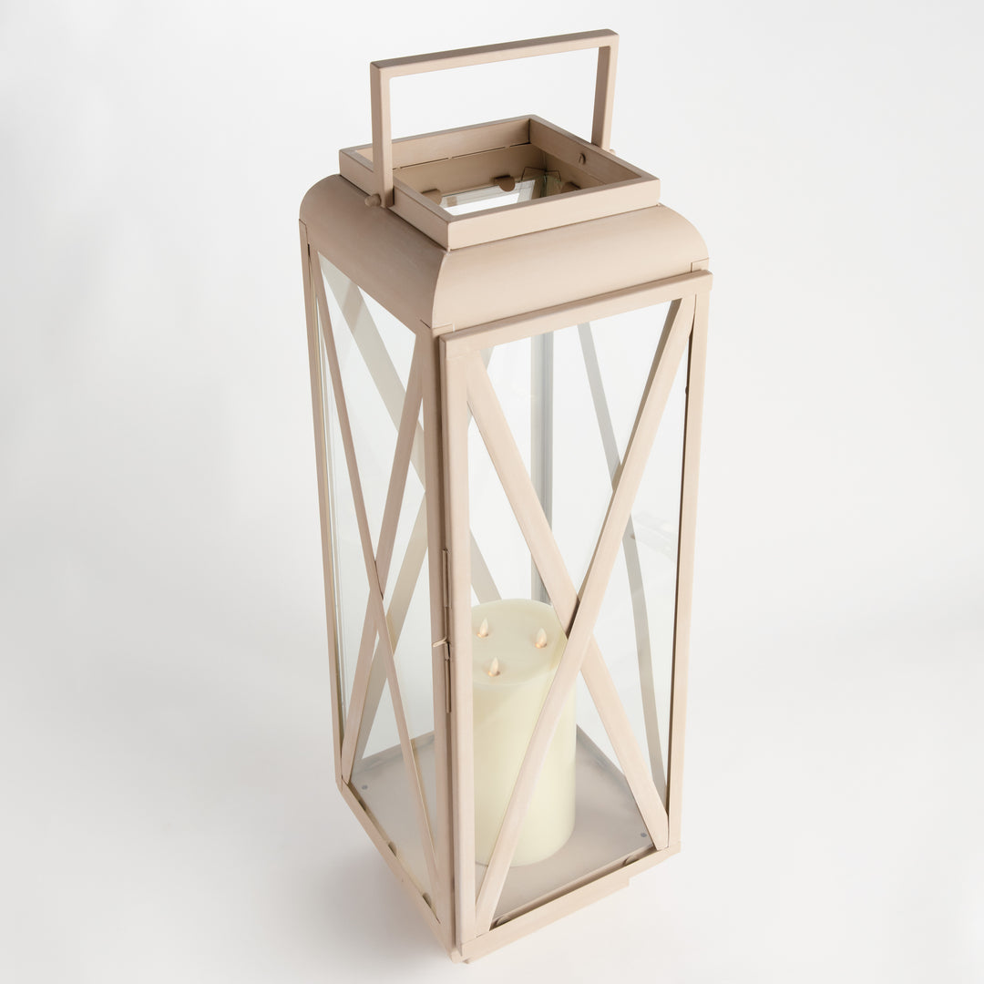 Close-up of sandstone-look outdoor lantern showing decorative cross-brace iron frame and clear glass panel, Modern Organic style