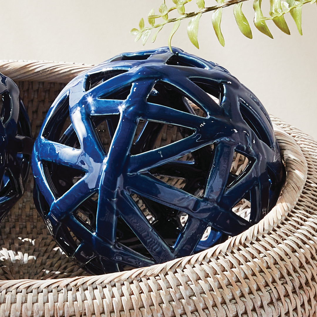 Blue ceramic decorative orbs styled in woven tray with glossy reactive glaze and open lattice detail – Coastal Transitional