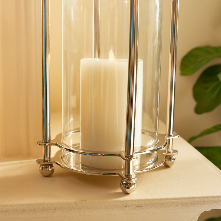 Detail of polished chrome base and glass cylinder on short hurricane candle holder
