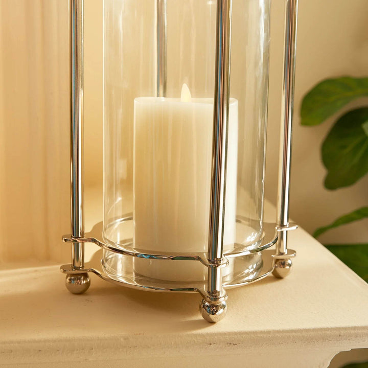 Detail of polished chrome base and glass cylinder on short hurricane candle holder
