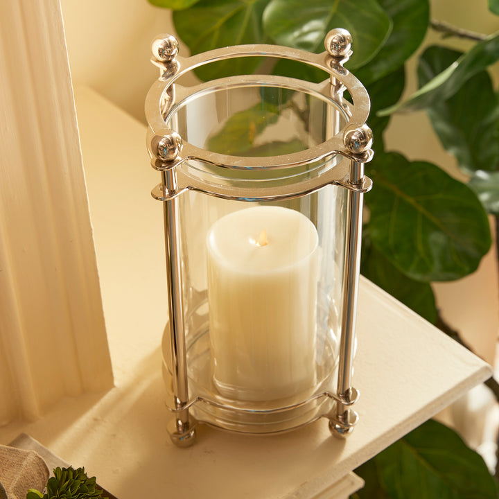 Top angle of short chrome hurricane candle holder with LED candle and finial accents
