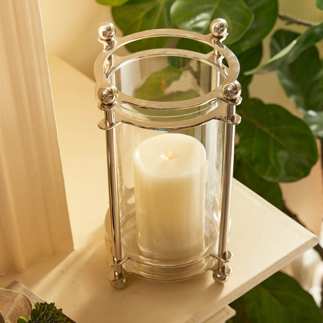 Top angle of short chrome hurricane candle holder with LED candle and finial accents
