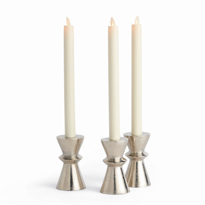 Set of three silver aluminum taper candle holders with hourglass bases, shown with ivory tapers for tabletop use – Modern Industrial