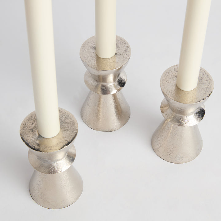 Top view of silver aluminum taper candle holders highlighting texture and matte reflective finish across sculptural surface – Transitional