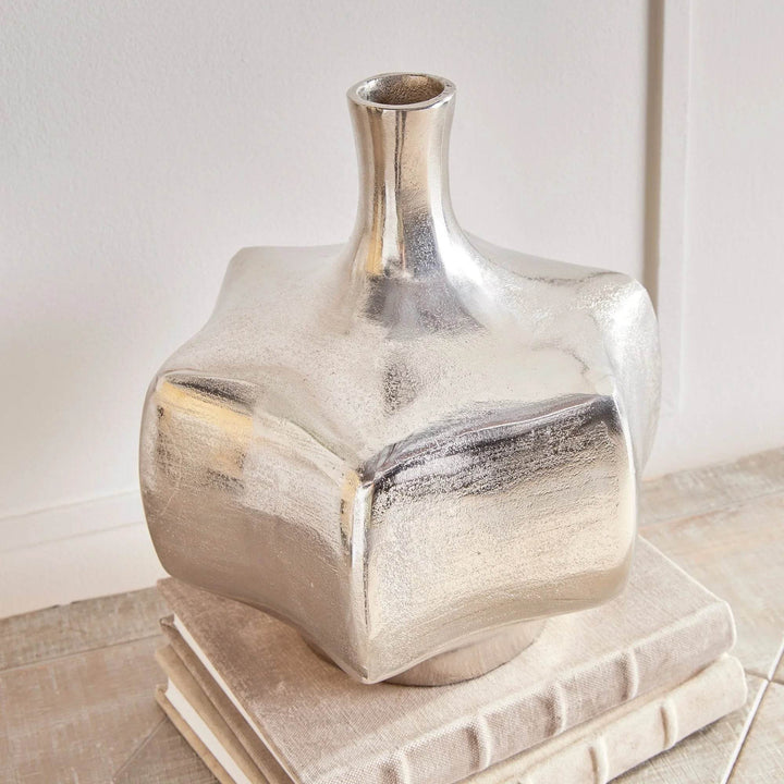 Closeup of silver cast aluminum vase showing texture and sculptural edges, metallic accent for modern interiors

