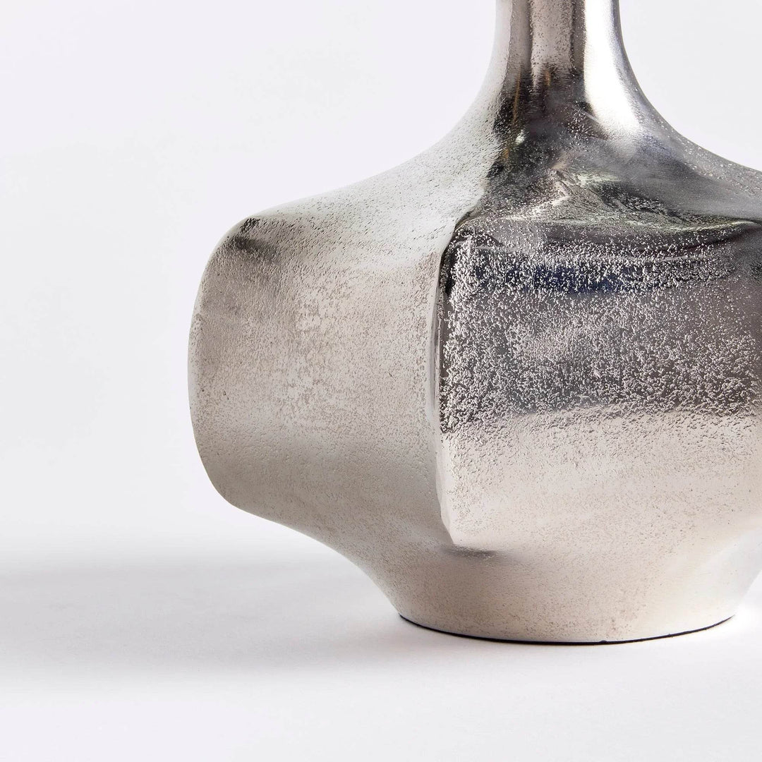 Side detail of small silver cast aluminum vase showing textured surface and reflective silver finish for modern decor


