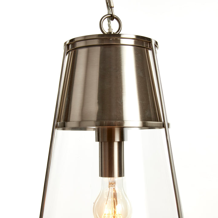 Close view of the silver pendant light showing metal cap, clear glass shade, chain connection and socket, Transitional style
