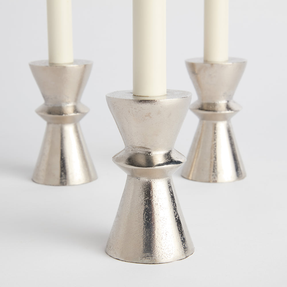 Silver aluminum taper candle holders shown angled in group of three, featuring cast hourglass silhouette and low profile – Minimalist