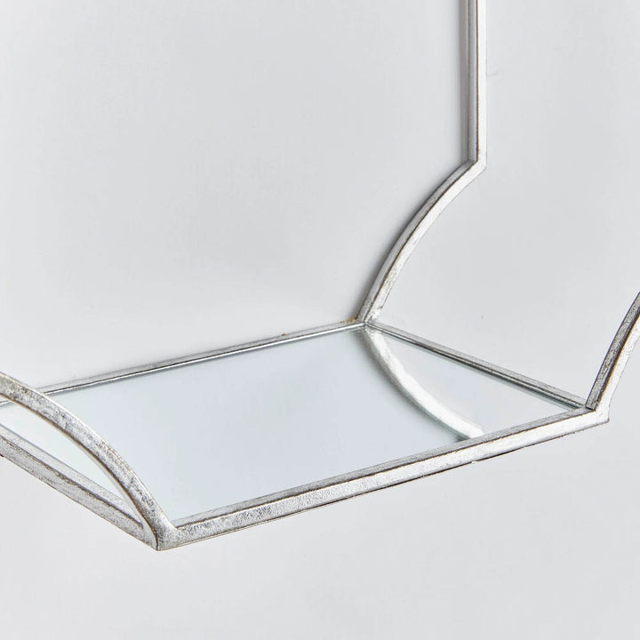 Close-up of the mirrored glass base and silver frame of an Art Deco wall shelf

