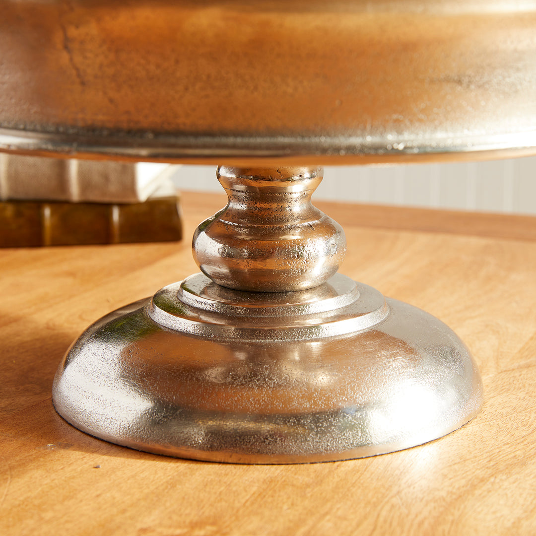 Close-up of round footed base on brushed silver aluminum pedestal display bowl – Modern Classic

