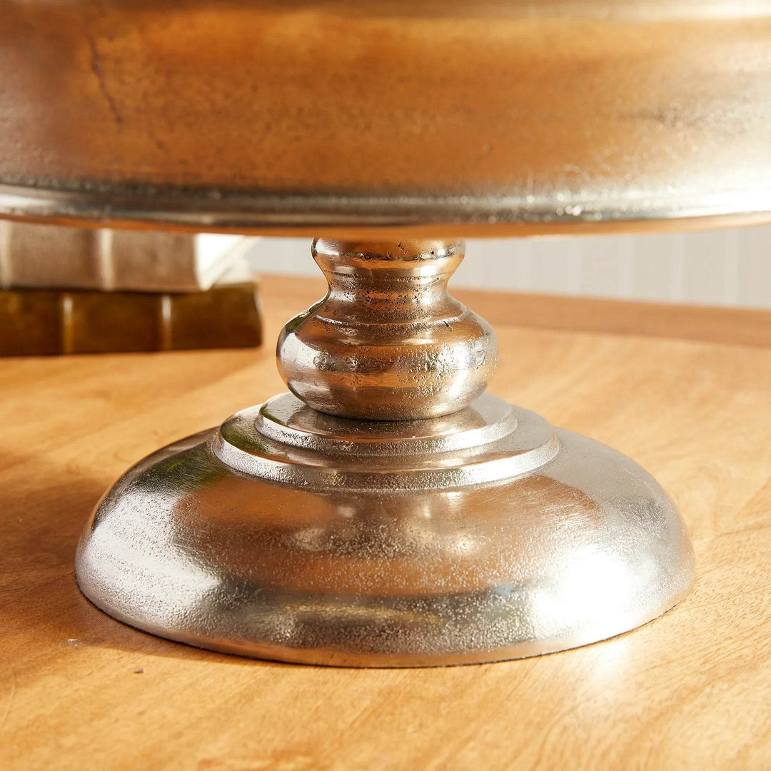 Close-up of round footed base on brushed silver aluminum pedestal display bowl – Modern Classic

