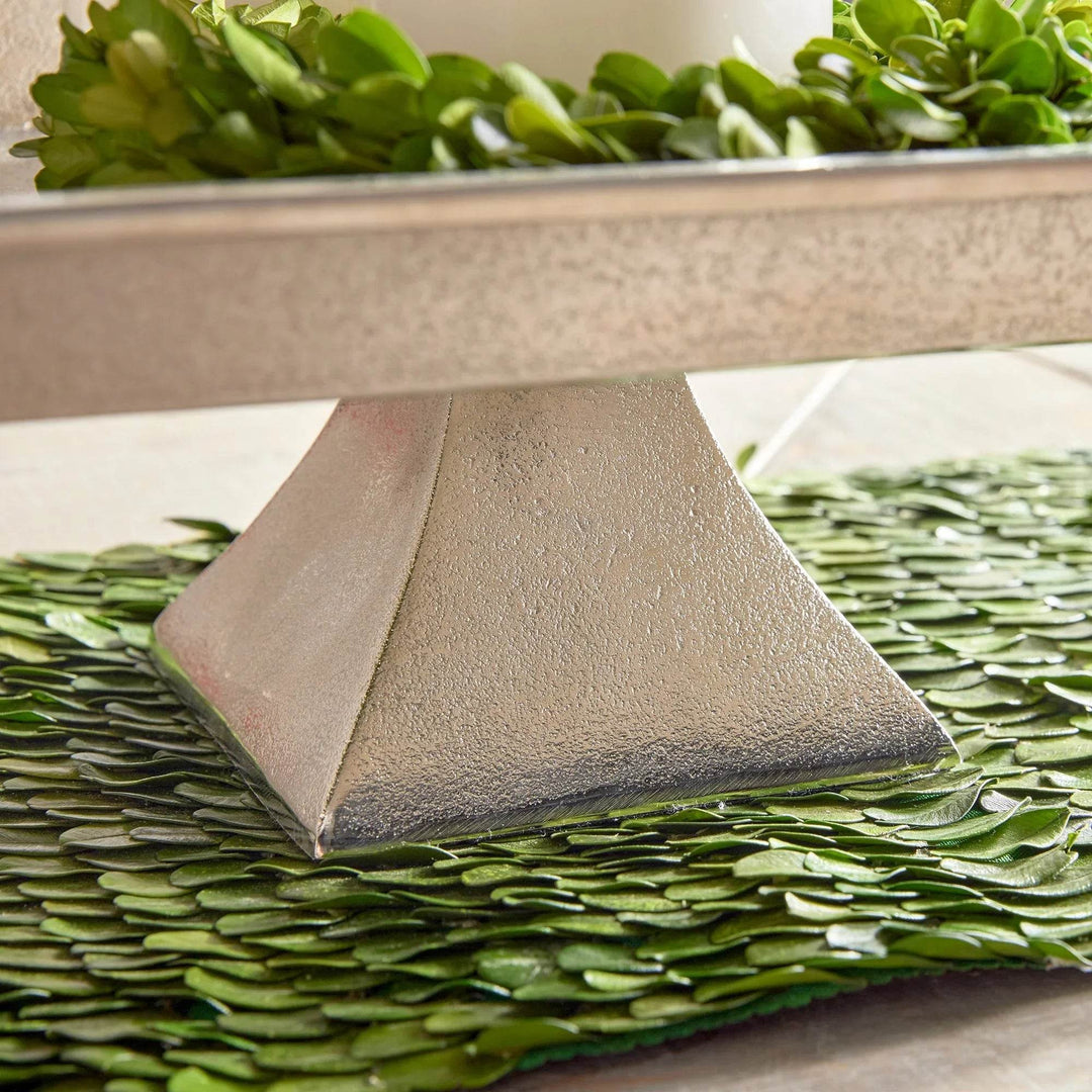 Side angle view of silver pedestal tray on brushed nickel base, displayed with greenery for modern traditional decor.


