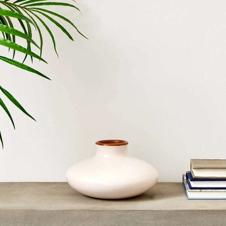 Handcrafted small beige ceramic vase styled on console with books and plant, adding artisan warmth to shelves and tables.

