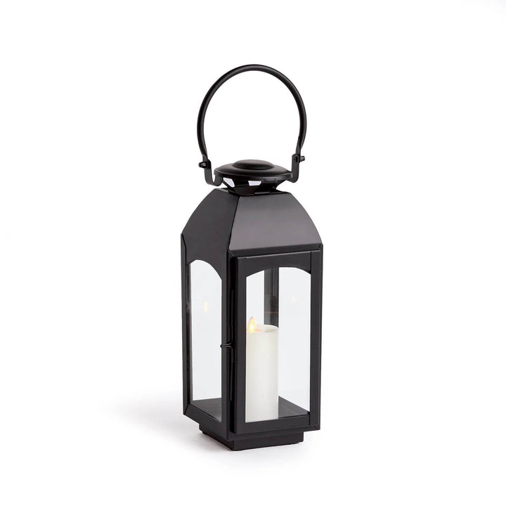 Small black outdoor lantern with iron frame and four clear glass sides, straight studio view on white with pillar candle centered – Transitional Decor