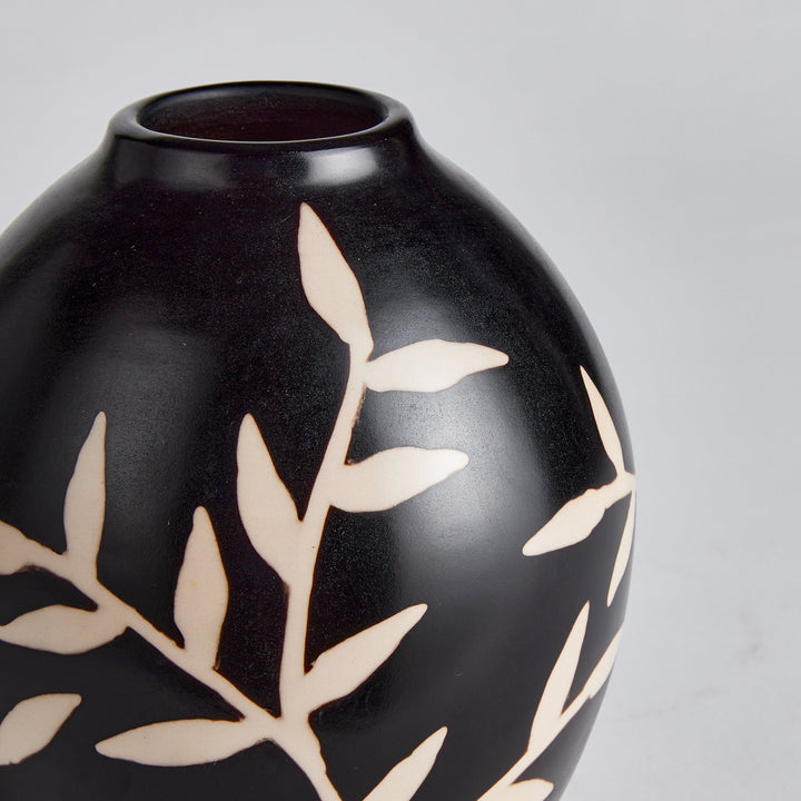 Close-up of etched vine detailing on matte black terracotta vase surface – Modern Organic.
