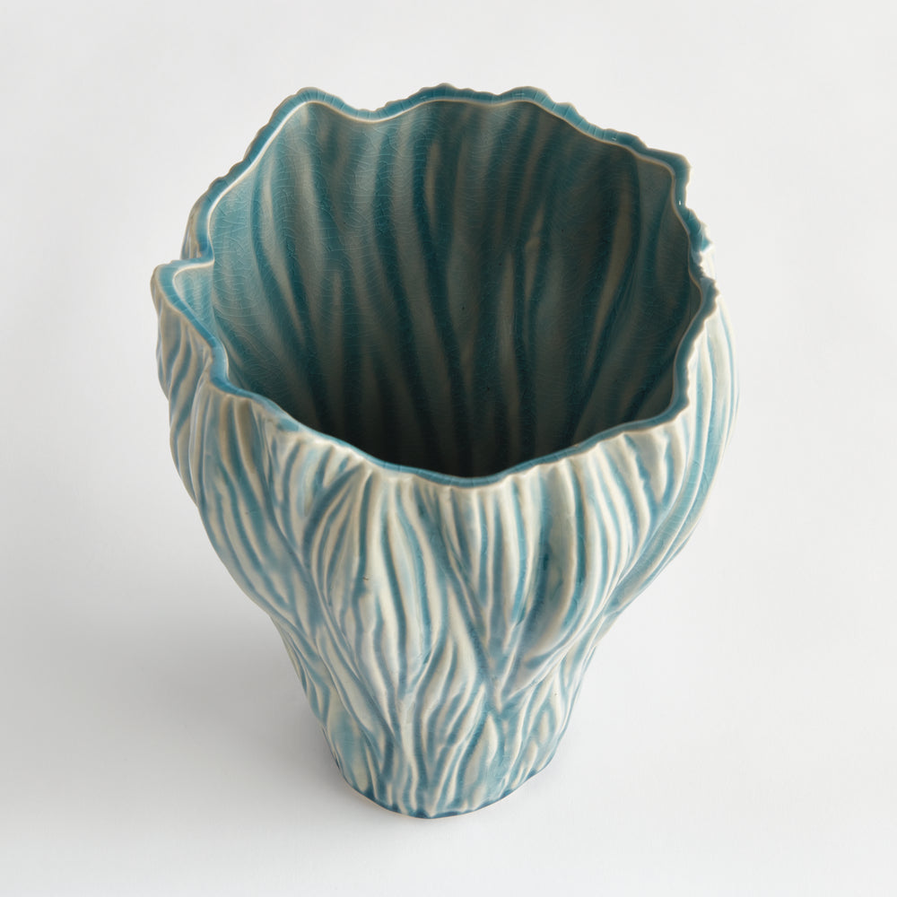 Angled view into a small blue ceramic vase with an irregular opening and flowing relief on its sides, Coastal Transitional