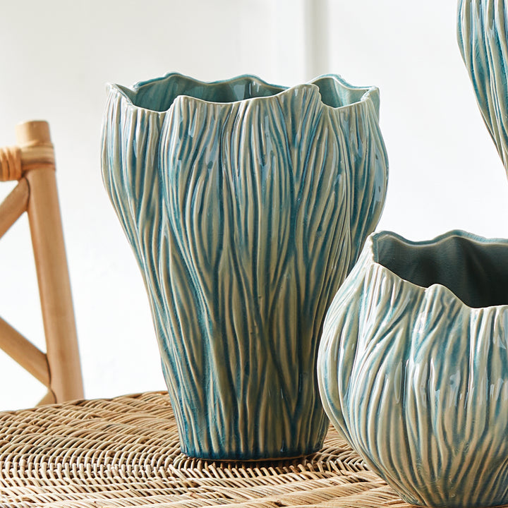 Small blue textured ceramic vase beside rounded cachepot and a taller matching vase on a woven surface, Coastal Transitional