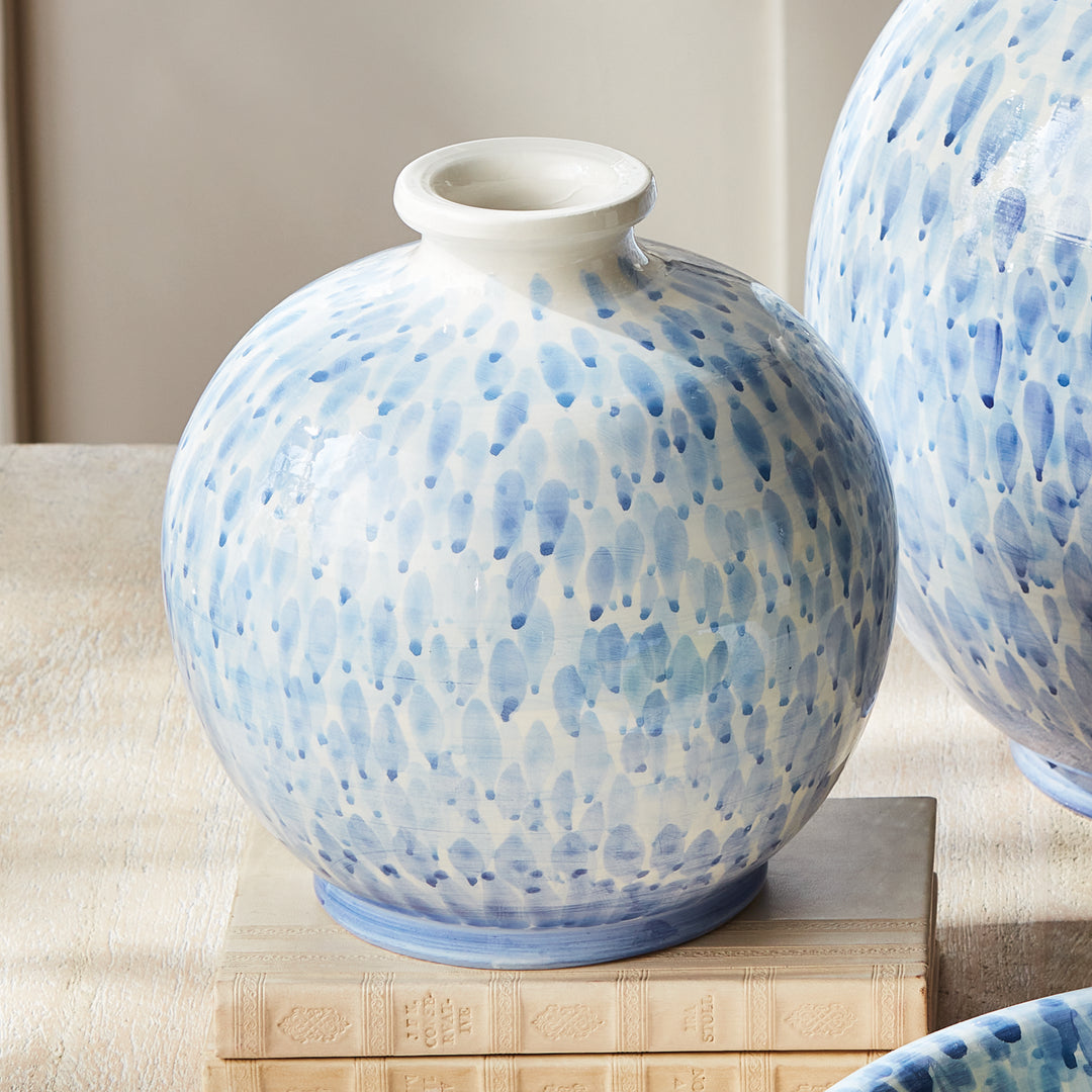 Small blue and white ceramic vase on stacked books beside a larger matching vase, styled on a console, Coastal Transitional