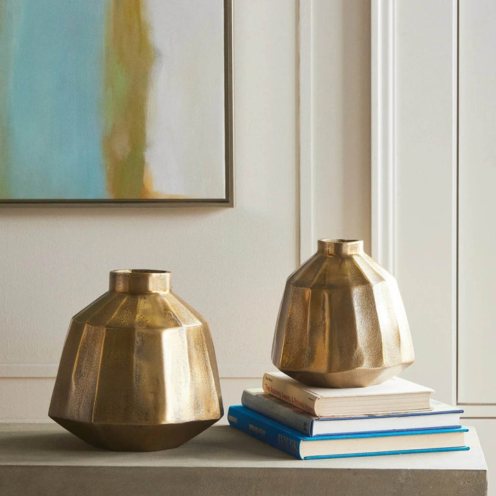 Small brass decorative vase paired with another vase, styled with stacked books on console, warm metallic accent – Contemporary Classic.
