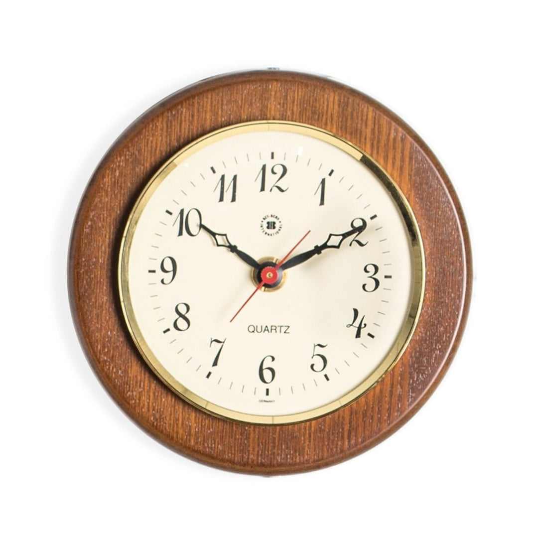 Small cherry wood wall clock with brass bezel and cream dial shown angled front view for classic study decor style