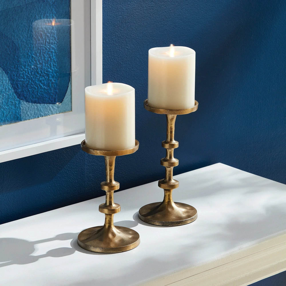 Pair of gold candle holders styled on console against navy wall with framed artwork and greenery – Contemporary Decor