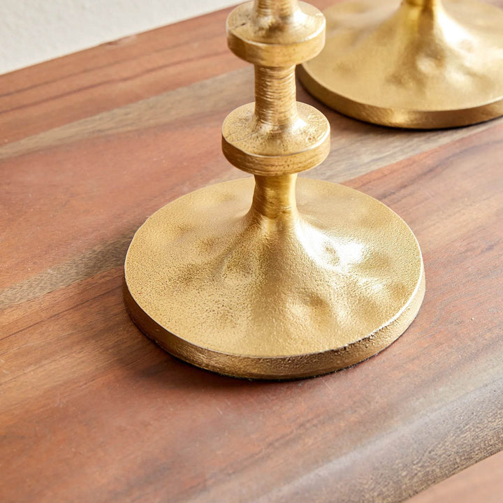 Side view of small gold candle stands with stepped notches and brushed finish, transitional modern style