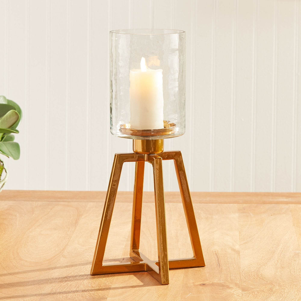 Gold metal hurricane candle holder with hammered glass, styled on wood console with soft natural light – Industrial Modern

