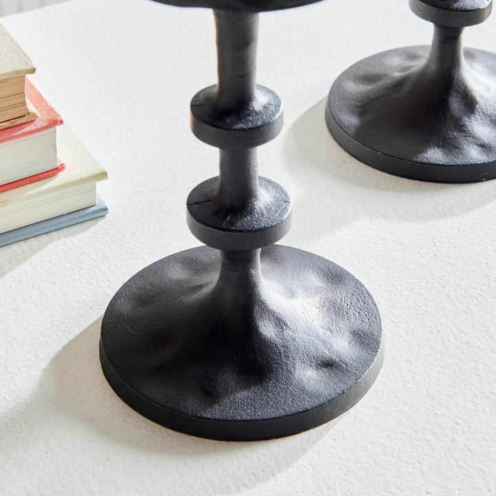 Close-up of notched column and base detail on small black bronze candle holder showing aged finish – Industrial