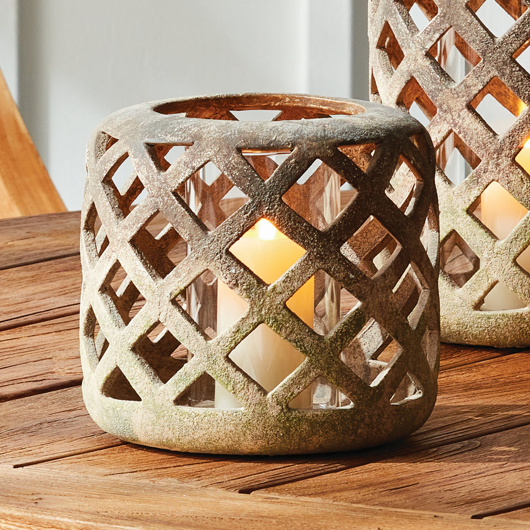 Small moss terracotta hurricane candle holder styled with candlelight on wood tabletop – European Transitional style.