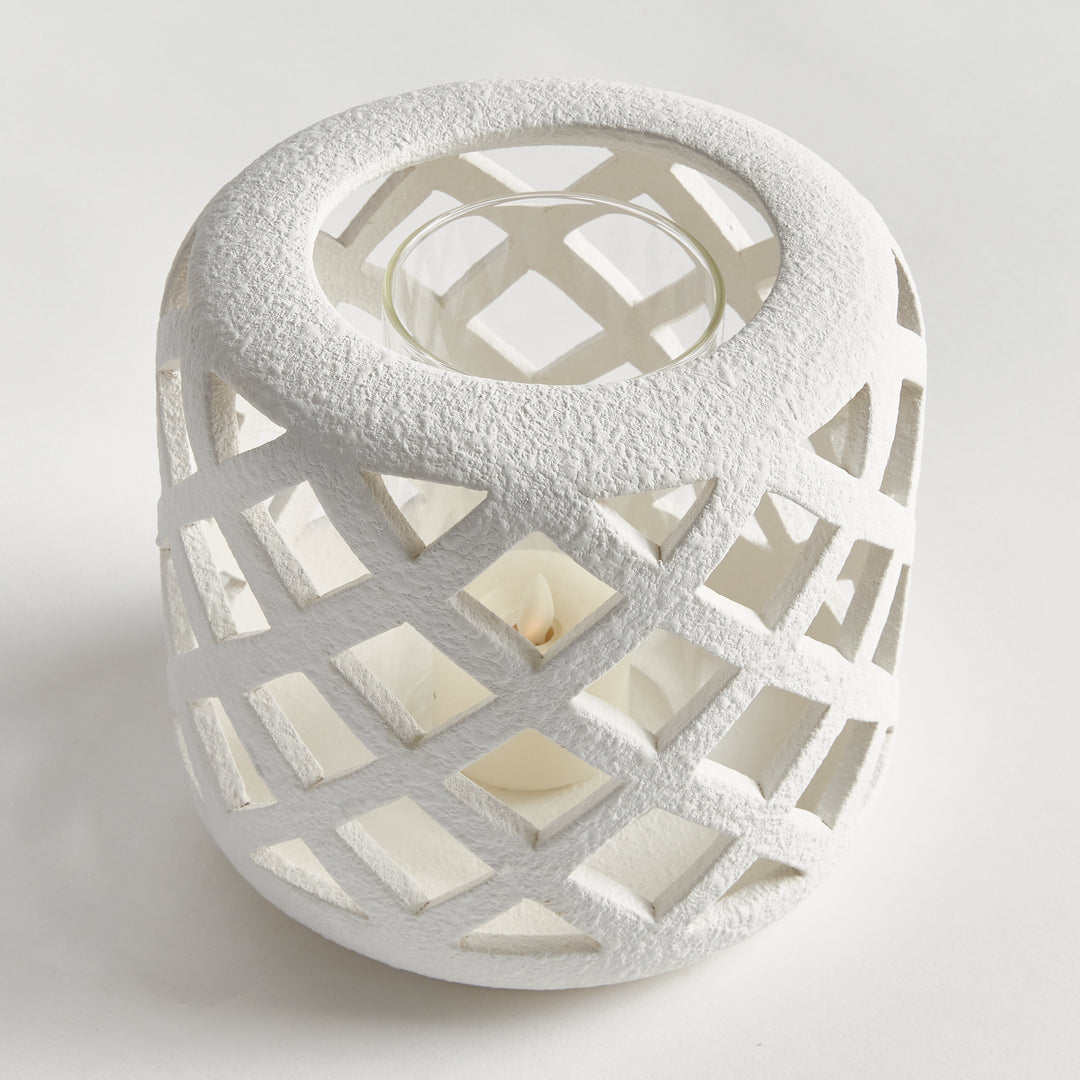 Angled view of small white terracotta hurricane candle holder with lattice cutouts – Coastal Transitional style.