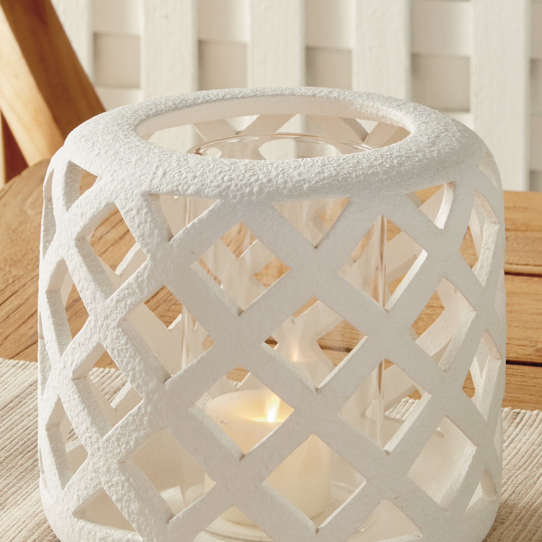 Small white terracotta hurricane candle holder styled on wood tabletop with candlelight – Modern Organic style.