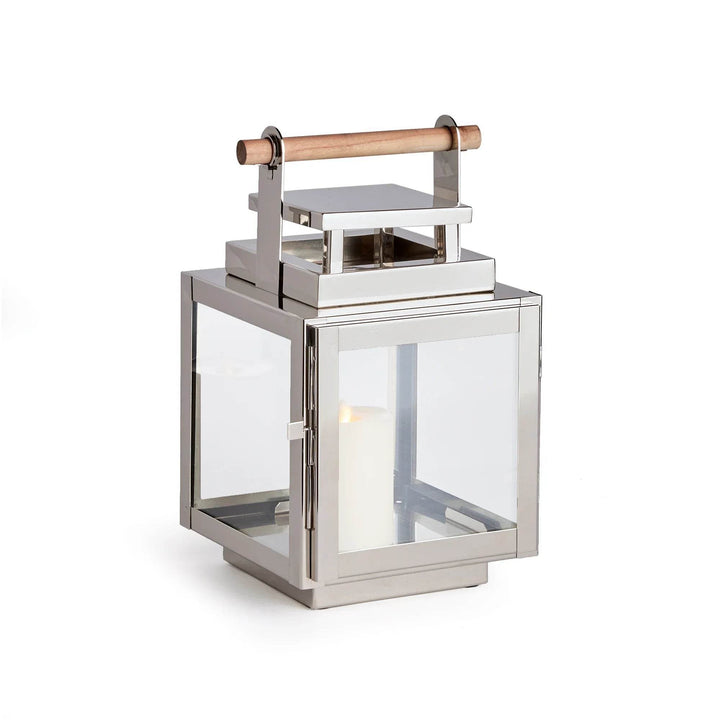 Studio view of small silver lantern with teak handle and candle inside