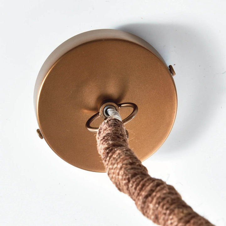 Small rattan pendant ceiling canopy close-up showing a round gold-colored plate and natural jute-wrapped chain, Coastal style