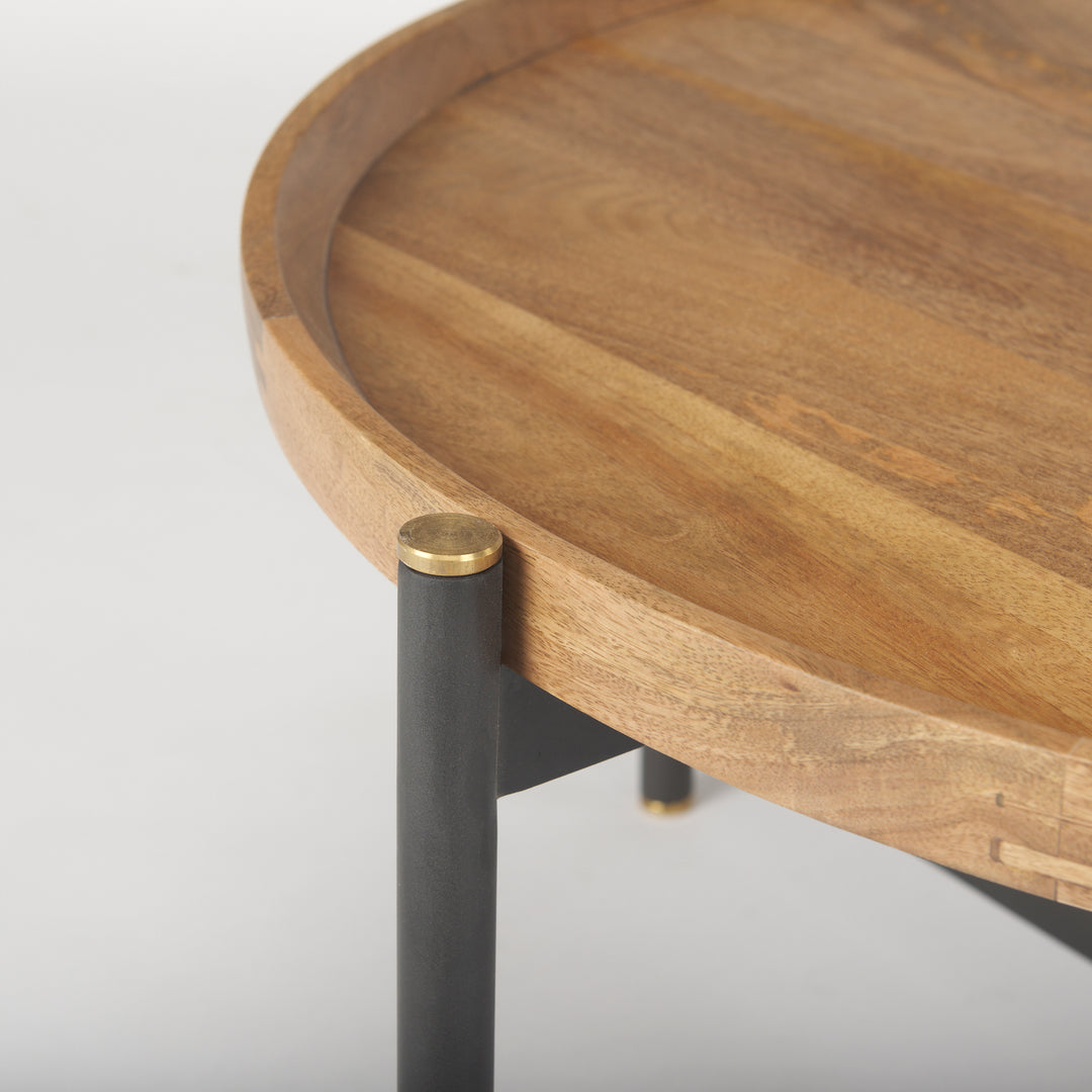 Close-up of the rounded mango wood tabletop edge with black iron frame and gold leg cap detail, Modern Organic coffee table