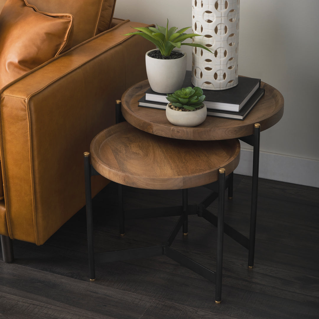 Small round mango wood coffee table styled beside a leather accent chair with black iron base, Modern Organic coffee table
