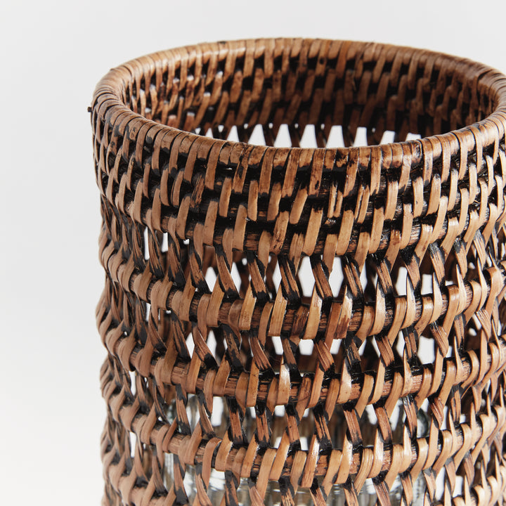 Close view of a small warm brown rattan hurricane showing the woven rim and open woven pattern against white, Transitional
