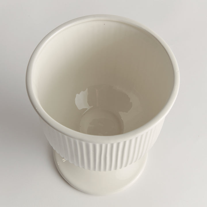 Overhead view into a small white ceramic footed cachepot with ribbed sides and a smooth rounded open interior, Traditional