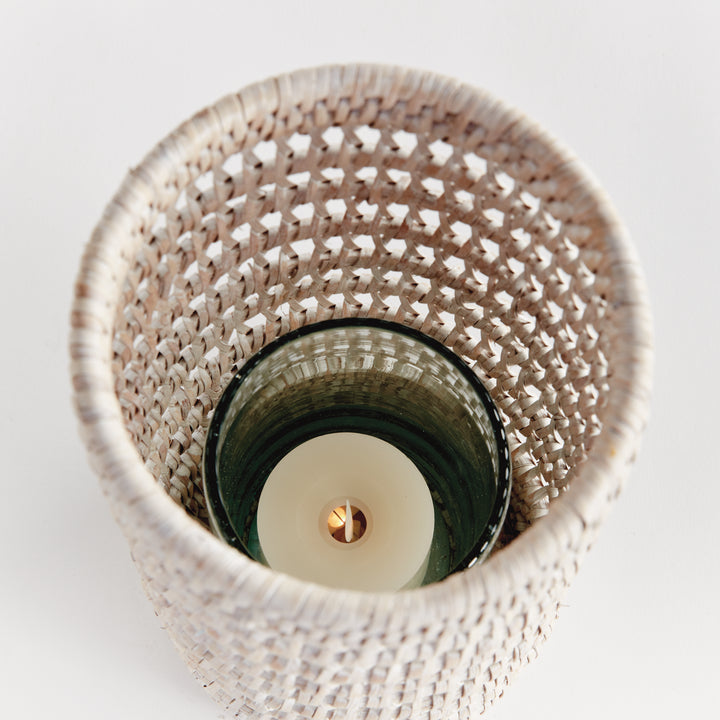 Top view into a small whitewash rattan hurricane showing a candle inside the glass insert and the woven sides, Transitional