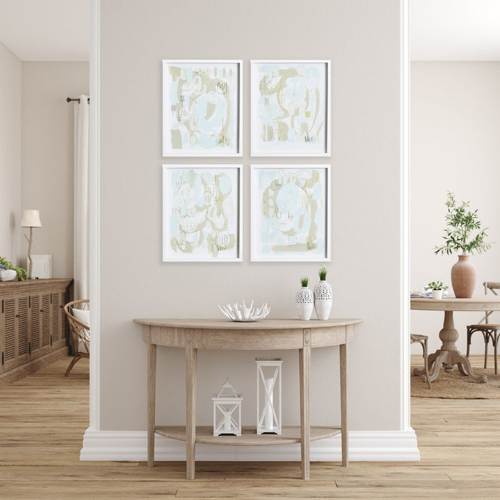 Set of four soft modern abstract prints in blue and green tones, framed in white and styled in a minimalist coastal entryway setting.