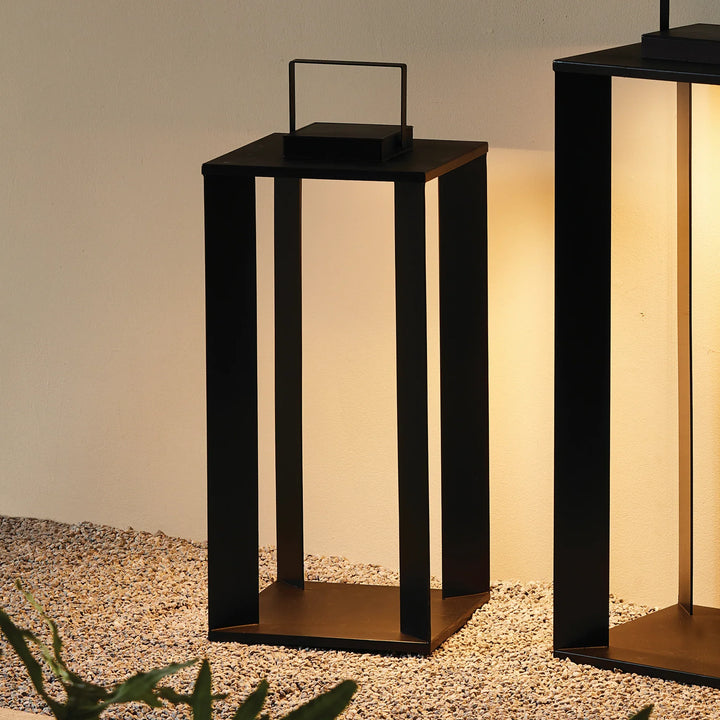 Set of solar LED lanterns in multiple sizes with warm glow arranged outdoors for layered modern lighting display