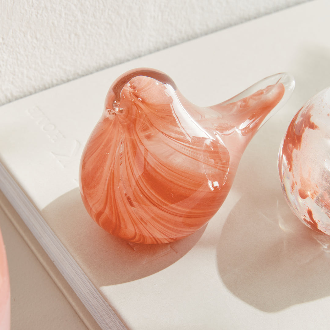 Single hand blown solid melon glass finch sculpture with smooth rounded form, small decorative bird accent.