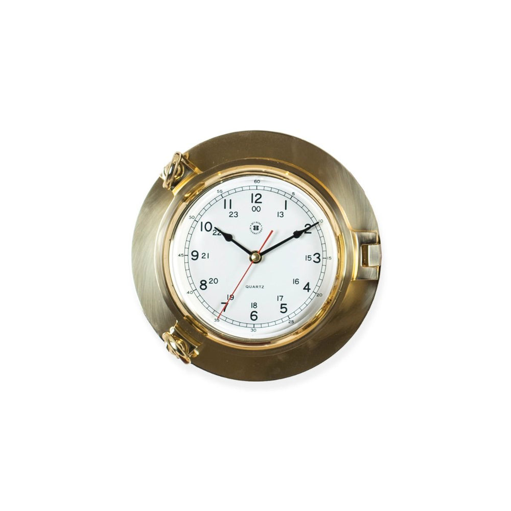 Solid brass porthole wall clock with beveled glass shown angled front view for nautical inspired office decor style
