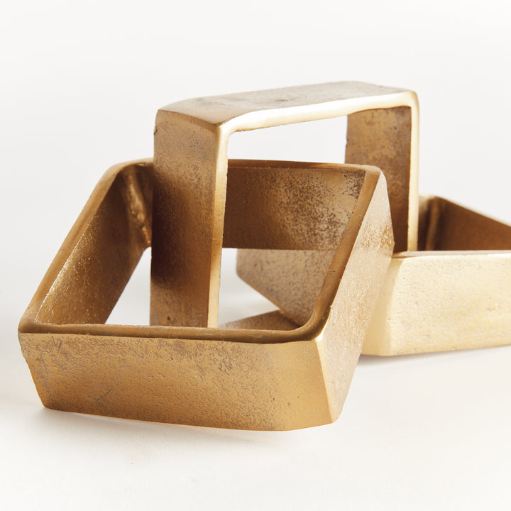 Close view of gold chain-link sculpture showing overlapping square links, textured aluminum and broad bands - Modern Organic