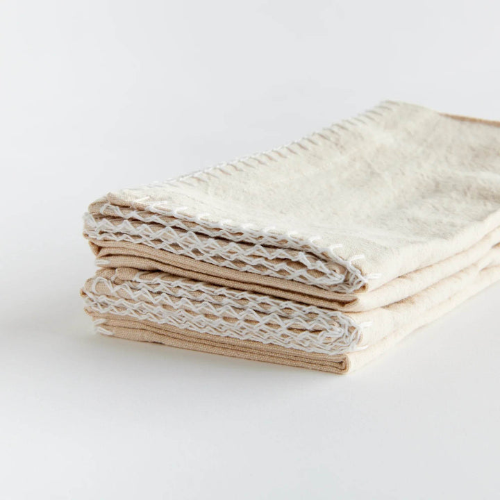 Stack of taupe cotton dinner napkins folded neatly with visible edge stitching, reusable and washable – Modern Farmhouse.