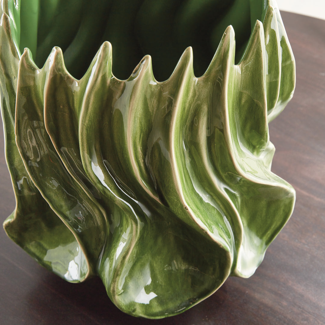 Detail of Sylva large green vase showing the glossy sculptural curves and pointed rim on a dark tabletop. Modern Organic